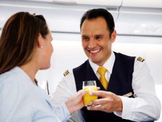 Lufthansa service in business class flight attendant serving orange juice to a passenger