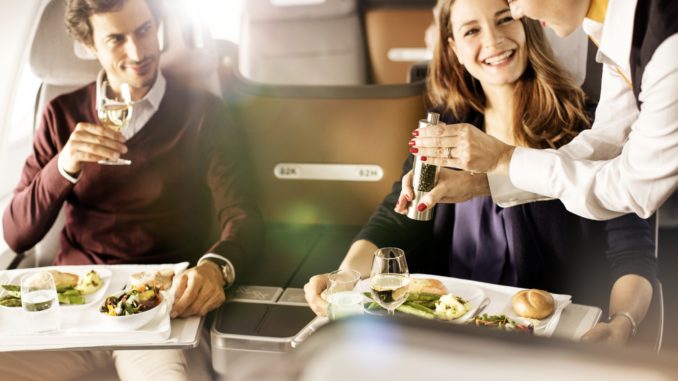 Passengers are offered pepper by a Lufthansa flight attendant during the meal service in business class