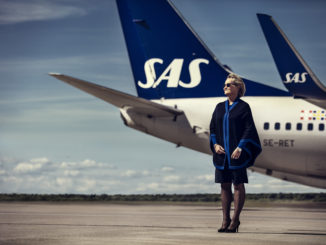 SAS flight attendant with the new uniform in front of a Boeing 737